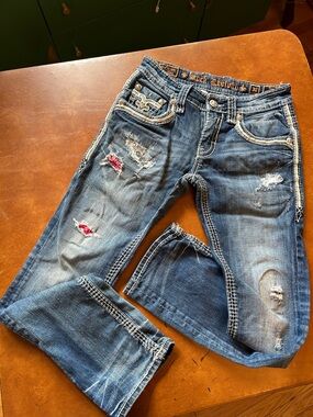 Rock Revival Distressed Bootcut Jeans in Blue with Red Patch Accents